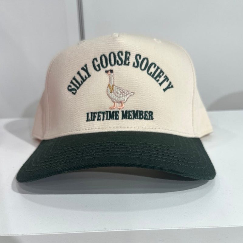 Beige and black cap with 'Silly Goose Society Lifetime Member' text on a white surface.