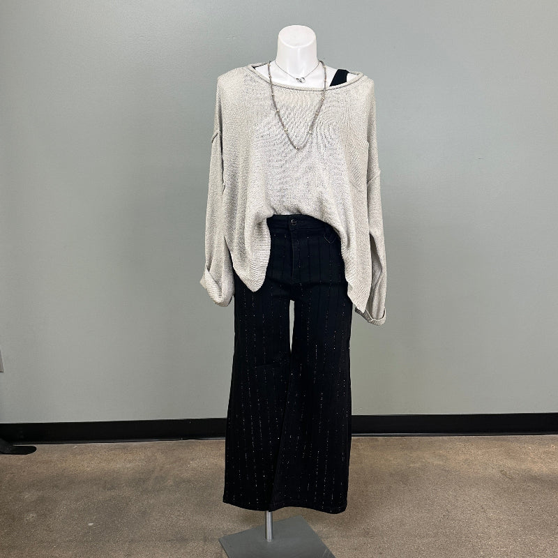 Mannequin wearing a gray sweater and black pants in a store setting