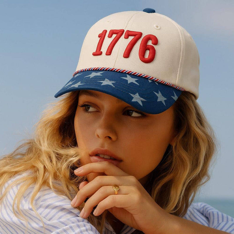 Person wearing a cap with '1776' on it against a clear sky.