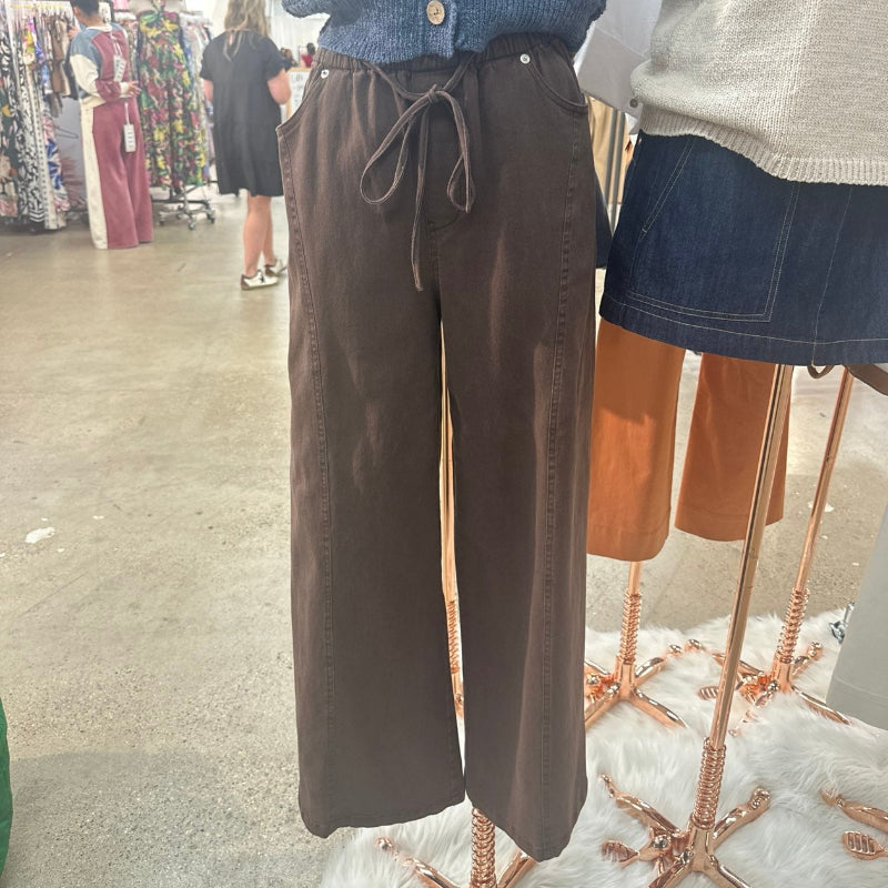 Brown wide-leg pants on a mannequin in a store setting