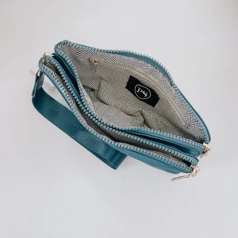 Blue clutch bag with a patterned interior on a light gray background