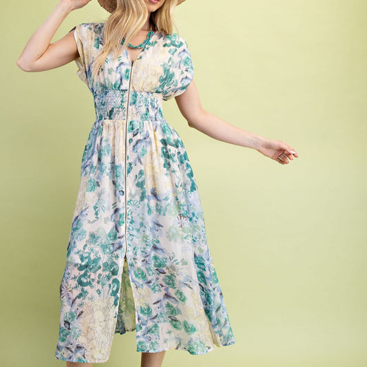 Woman wearing a floral dress and straw hat on a light green background