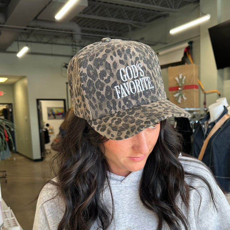 Person wearing a leopard print cap with text in an indoor setting