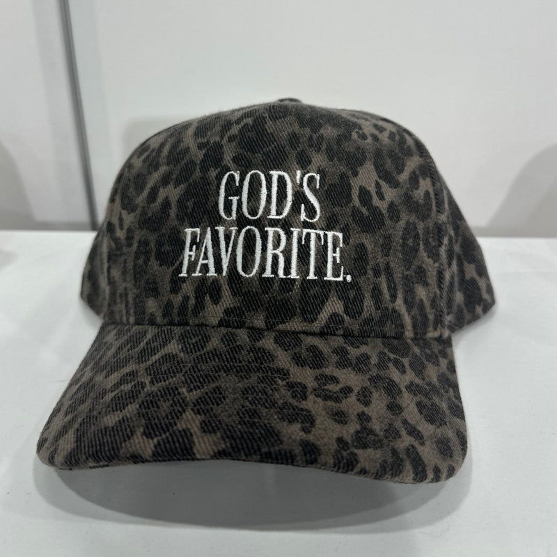Leopard print cap with 'GOD'S FAVORITE' text on a white surface.