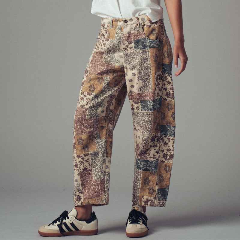 Patchwork patterned pants worn by a person on a gray background