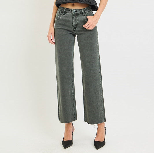 A woman modeling a dark gray ruffled camisole top and wide-leg cropped gray jeans with black pointed-toe heels, standing against a plain light gray studio background.
