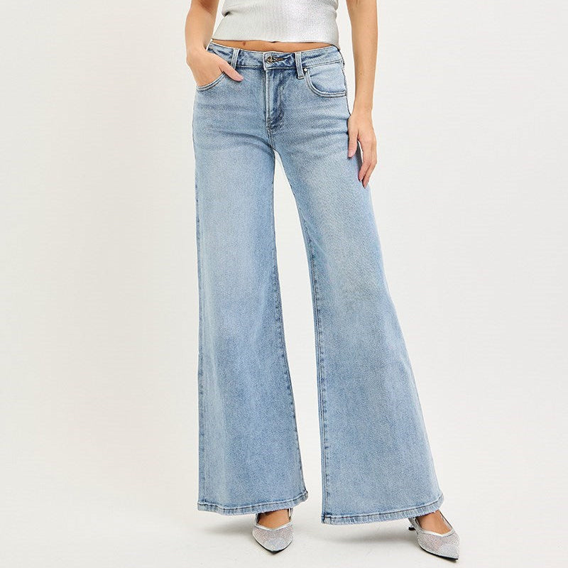 Woman wearing a white strapless top and light blue jeans on a white background