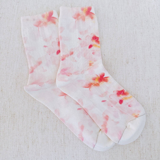 Floral-patterned socks on a textured beige background