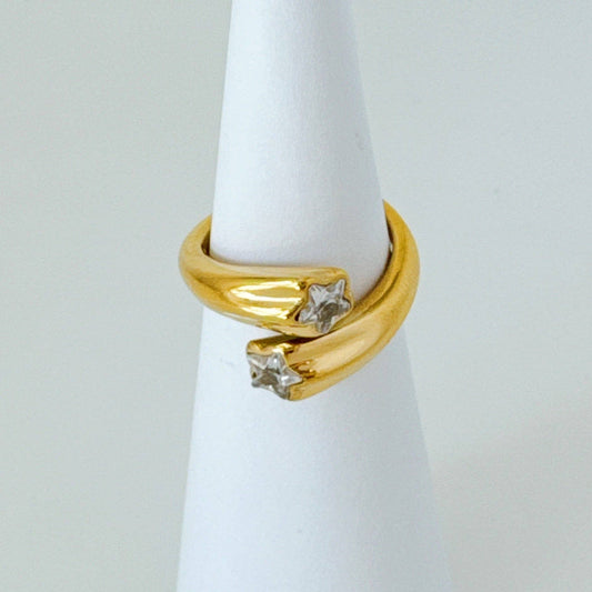 Gold ring with diamonds on a white mannequin finger against a light gray background
