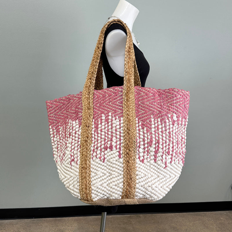 Woven bag with pink pattern on a gray surface
