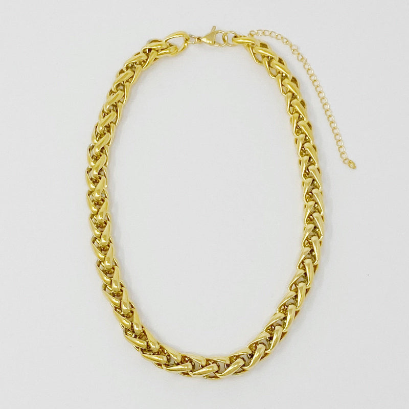 Gold chain necklace on a light gray background