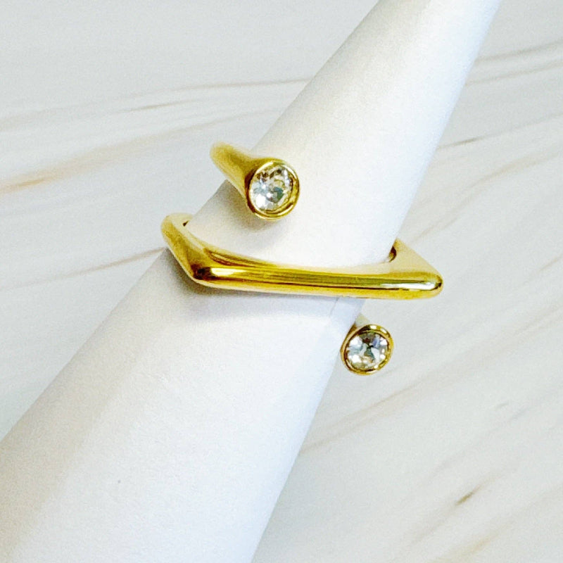 Gold ring with gemstones on a white marble surface