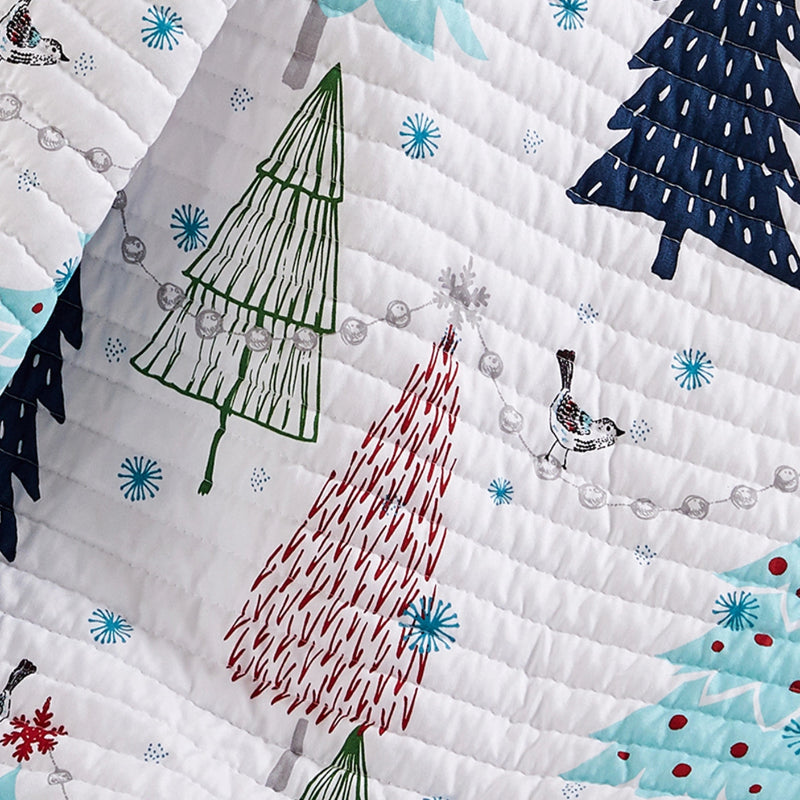 Quilt with colorful Christmas tree patterns and snowflakes on a white background